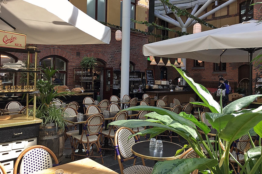 Utomhusterrass med rottingstolar och stora parasoller vid en europeisk caféstil